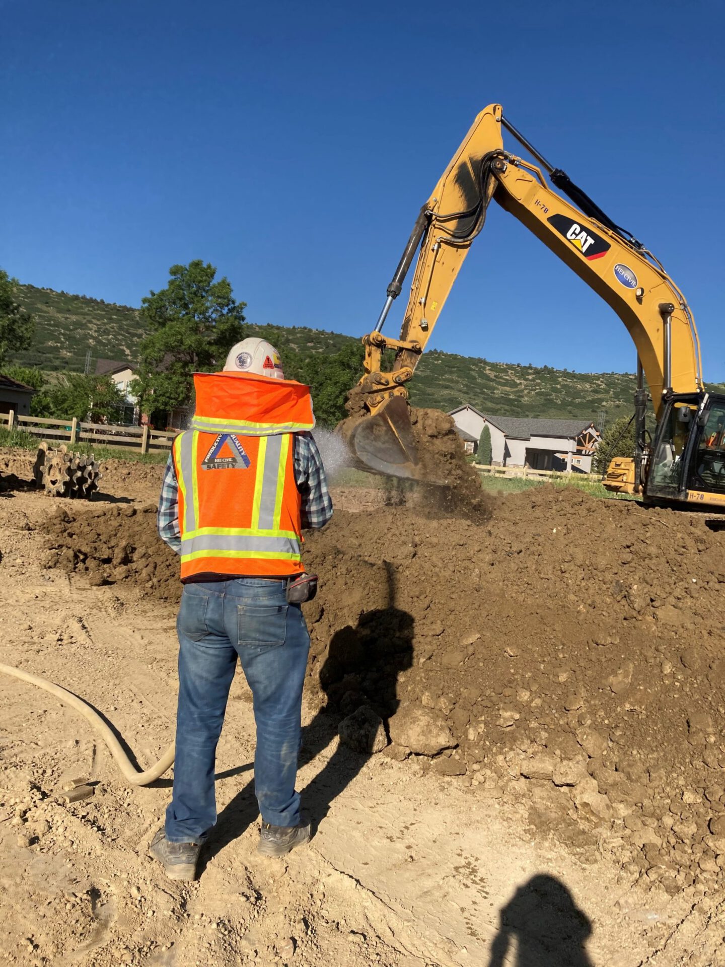 HEI Laborer watering soil for excavation.