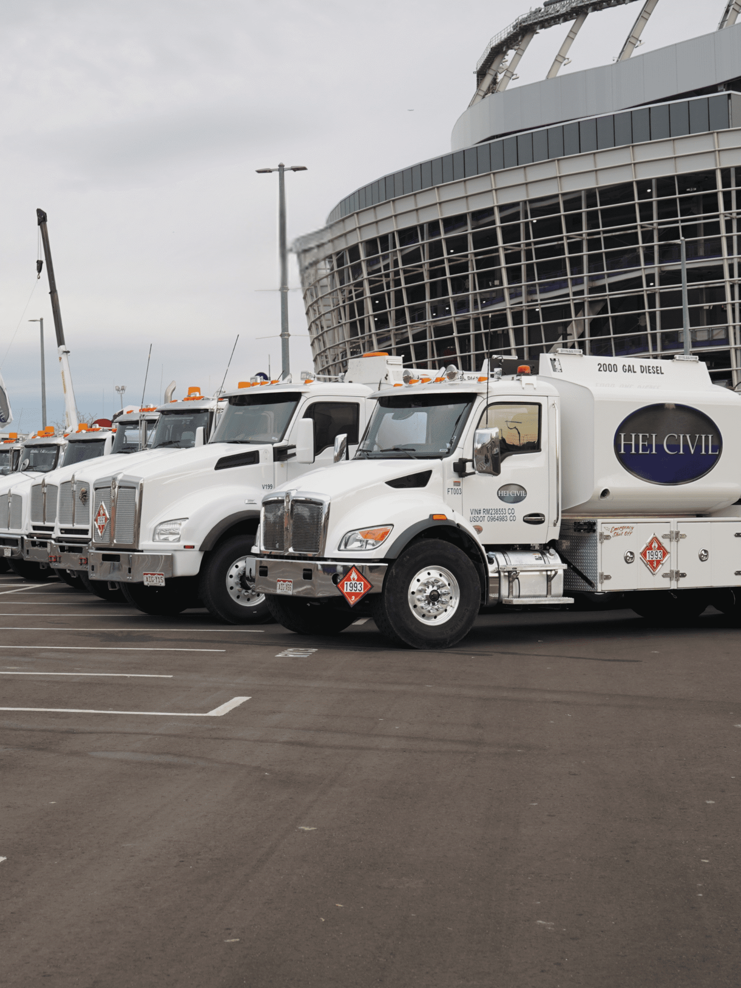 HEI CO Equipment Team's Fleet of Trucks Lined Up outside a stadium